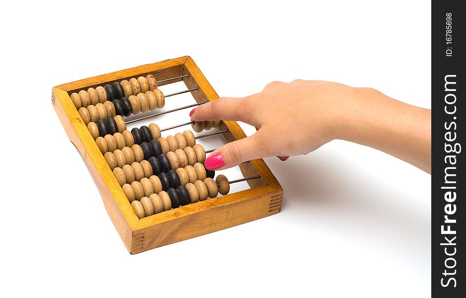 Female hand on old wooden an abacus it is isolated on a white background. Female hand on old wooden an abacus it is isolated on a white background.