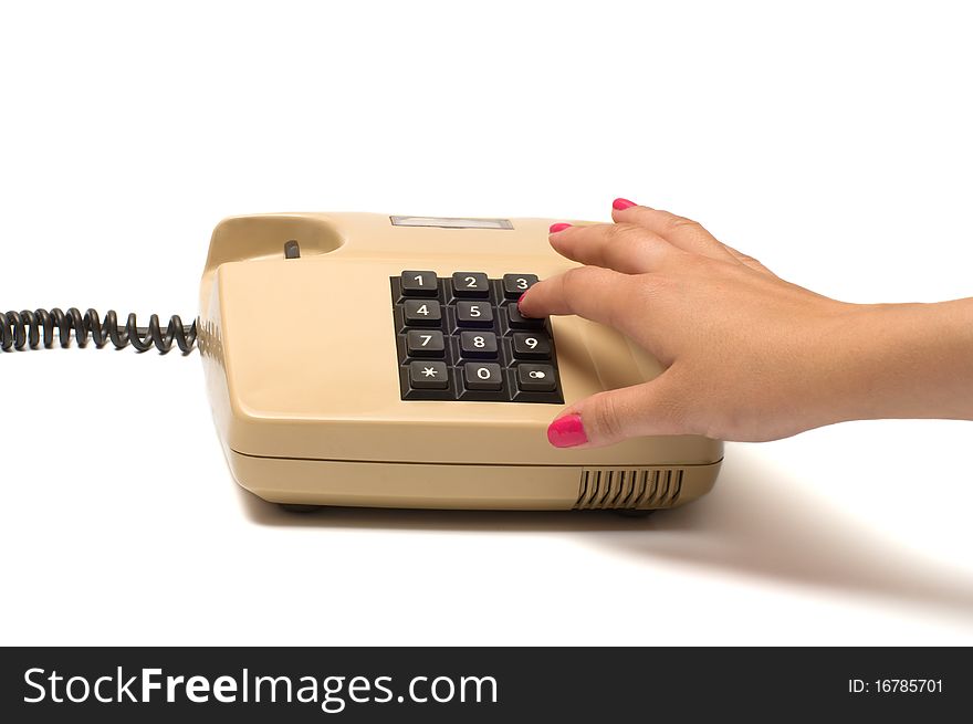 Female finger presses the button on the old phone isolated on white background. Female finger presses the button on the old phone isolated on white background.