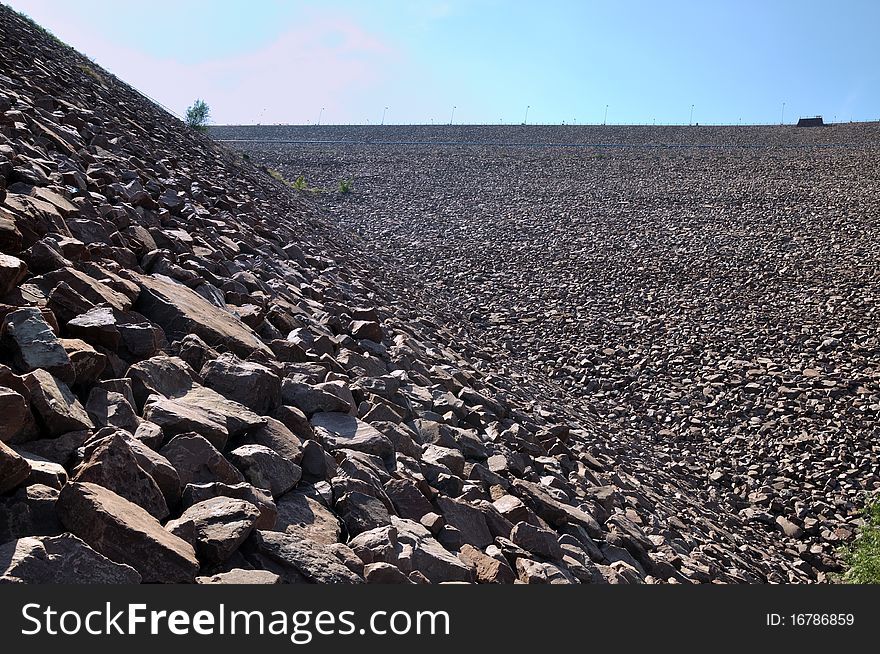 Slope of water dam built by stone, shown as construction and industrial solid and powerful. Slope of water dam built by stone, shown as construction and industrial solid and powerful.