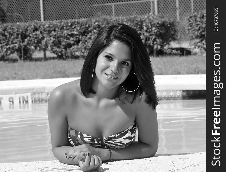 Young girl in the pool and smiling, big hoop earings. Young girl in the pool and smiling, big hoop earings