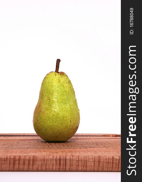 A Single Pear on a Cutting Board Isolated against a White Background