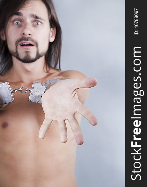 Chained in handcuffs long-haired caucasian guy