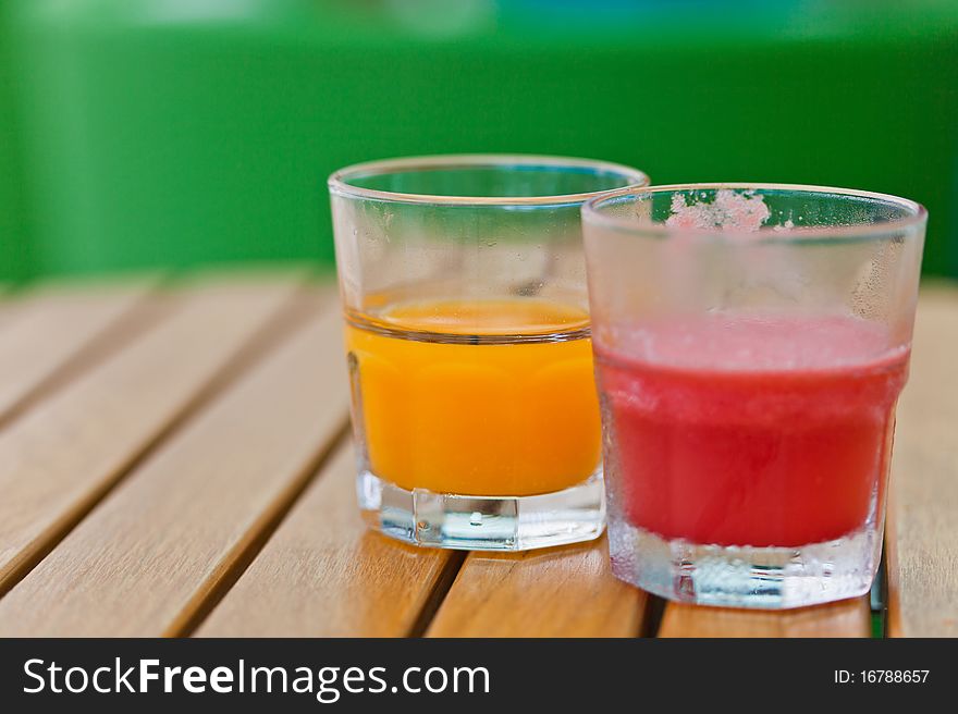 2 glass of fruit-juices on the wooden table. 2 glass of fruit-juices on the wooden table