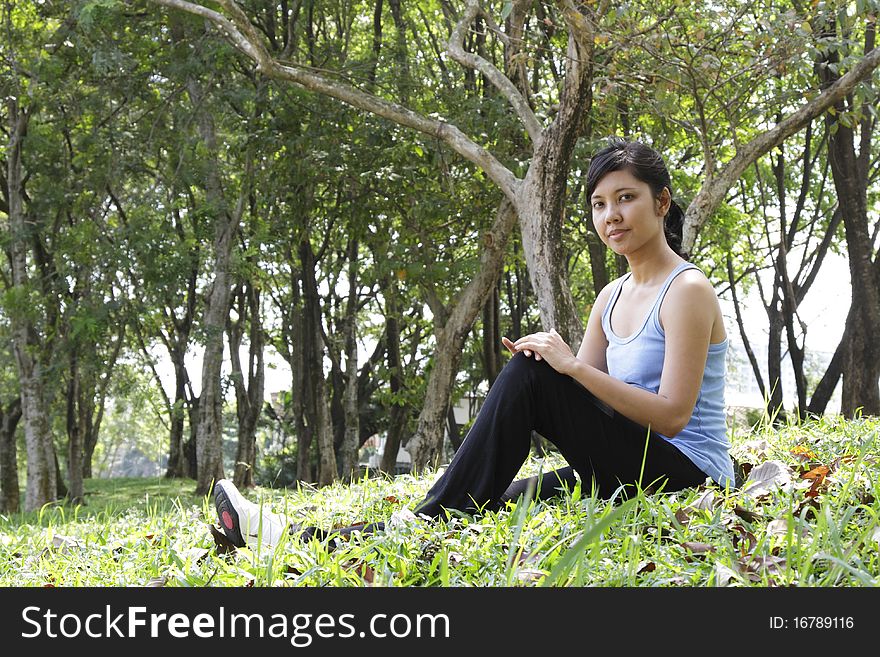 An Asian woman relaxing outdoors. An Asian woman relaxing outdoors