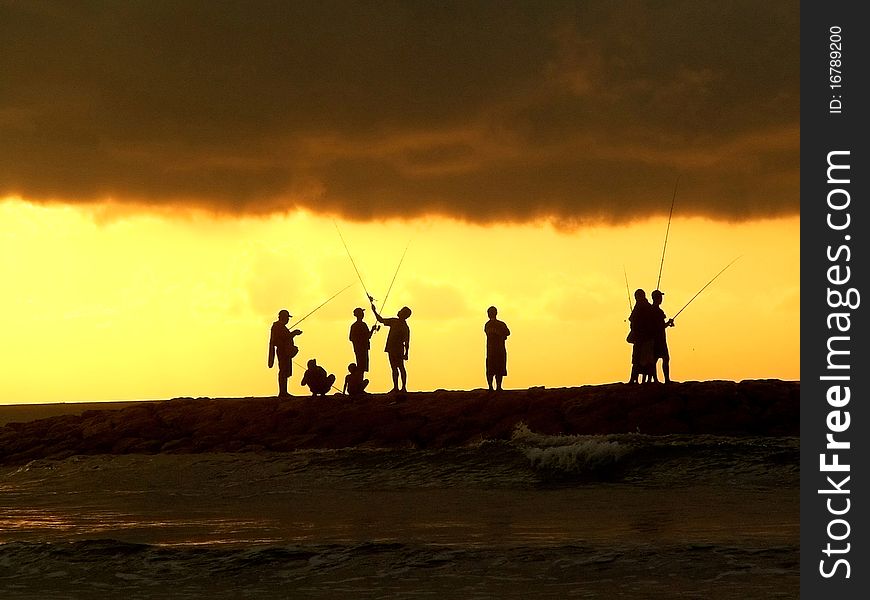 Fishermen outlines against the evening sky, Bali