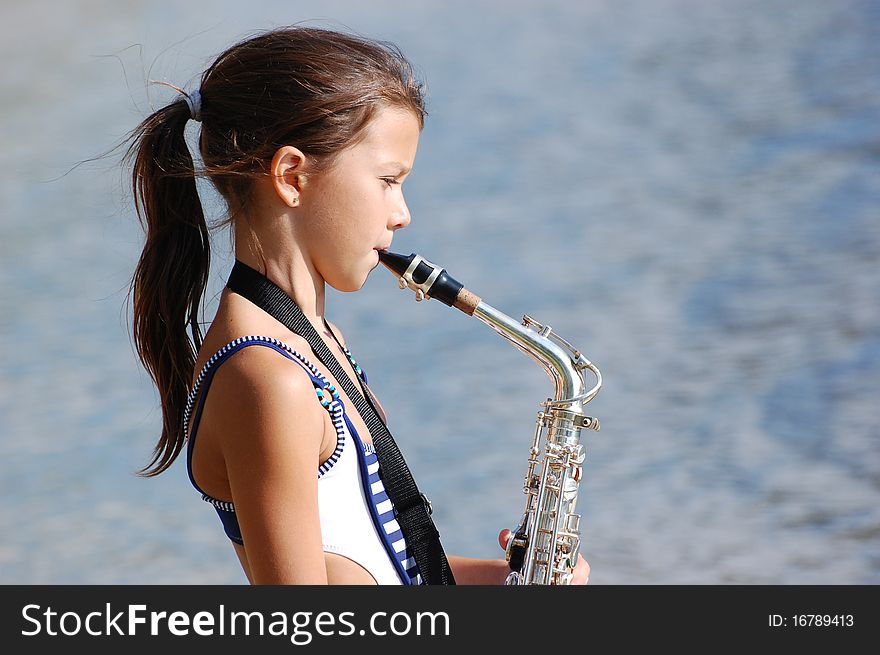 Girl with saxophone outdoor.Near Kiev,Ukraine