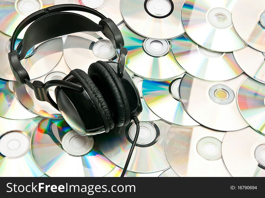 Black headphones on dvd background. Black headphones on dvd background