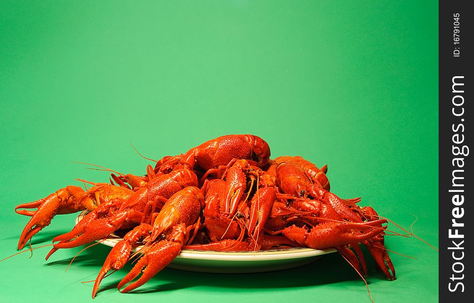 Plate full of red crayfishes, green background. Plate full of red crayfishes, green background