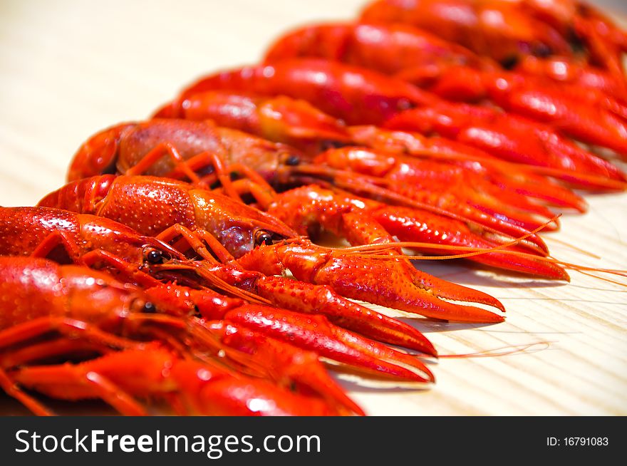 Row of a red crayfishes, wooden background