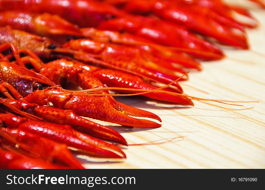 Row of a red crayfishes, wooden background. Row of a red crayfishes, wooden background