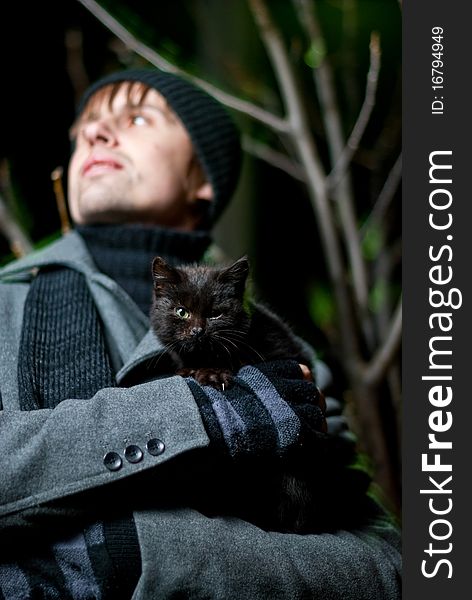 Young man holding black cat in his arms outdoor. Young man holding black cat in his arms outdoor