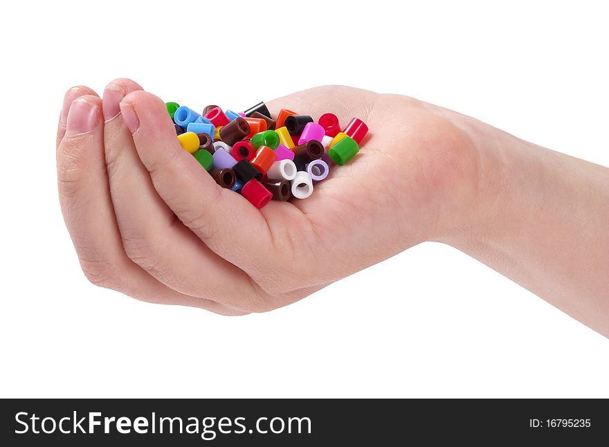 Plastic colorful mosaic particles in the child hand isolated over white background. Plastic colorful mosaic particles in the child hand isolated over white background