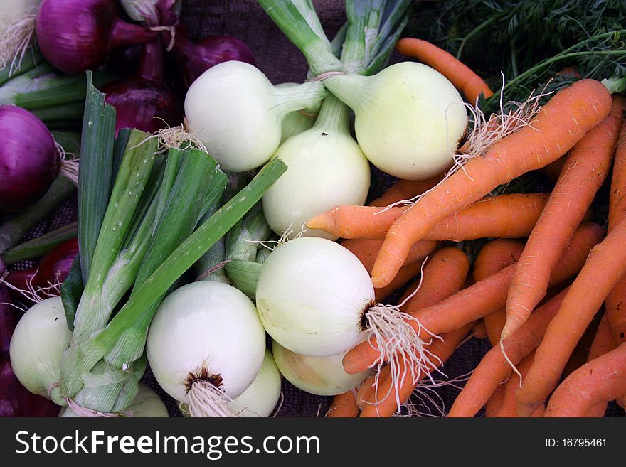 Colorful fresh vegetables carrots and onions at farmer’s market