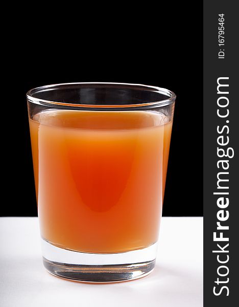 Grapefruit juce in the glass over black and white background. Grapefruit juce in the glass over black and white background