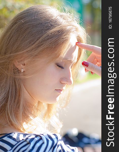 Portrait of a beautiful young woman thinking in the park. Portrait of a beautiful young woman thinking in the park