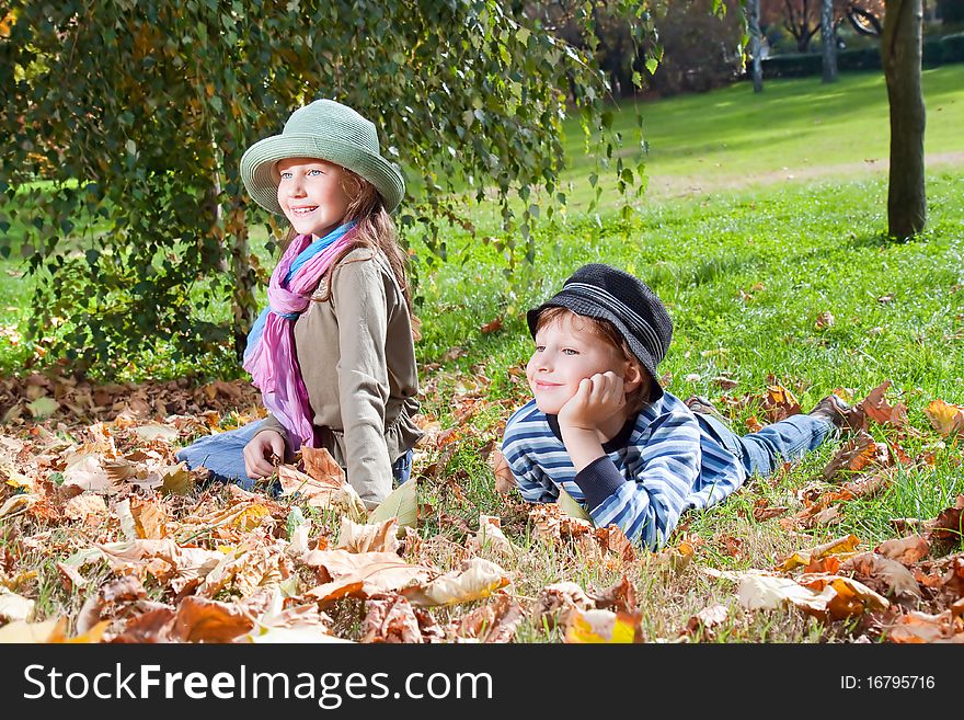 Happy girl and boy  enjoying golden autumn