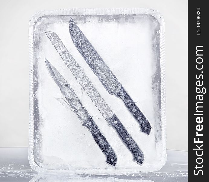 Still life composition: set of three knives frozen in the ice. Still life composition: set of three knives frozen in the ice