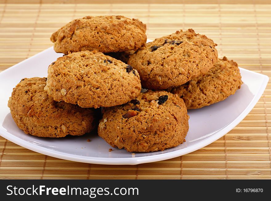 Oatmeal cookies with raisins laying on the white plate. Closeup.