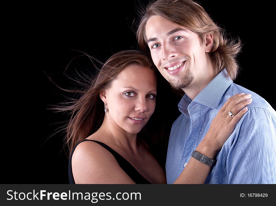 Young cute couple with long hair over black background. Young cute couple with long hair over black background.