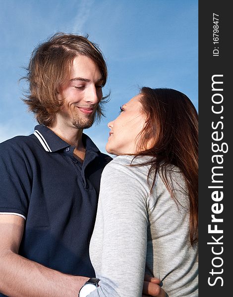 Young couple in love with blue sky in the background. Young couple in love with blue sky in the background