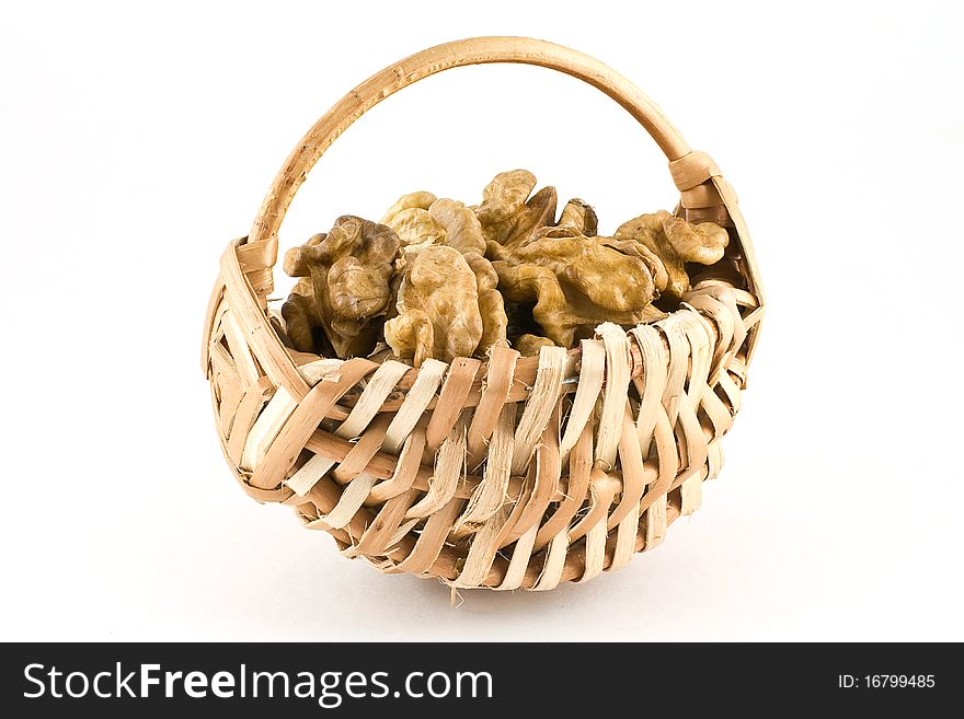 Shelled walnuts in a wicker basket isolated on white background