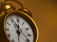 Golden Vintage Alarm Clock Showing Five To Twelve Stock Image