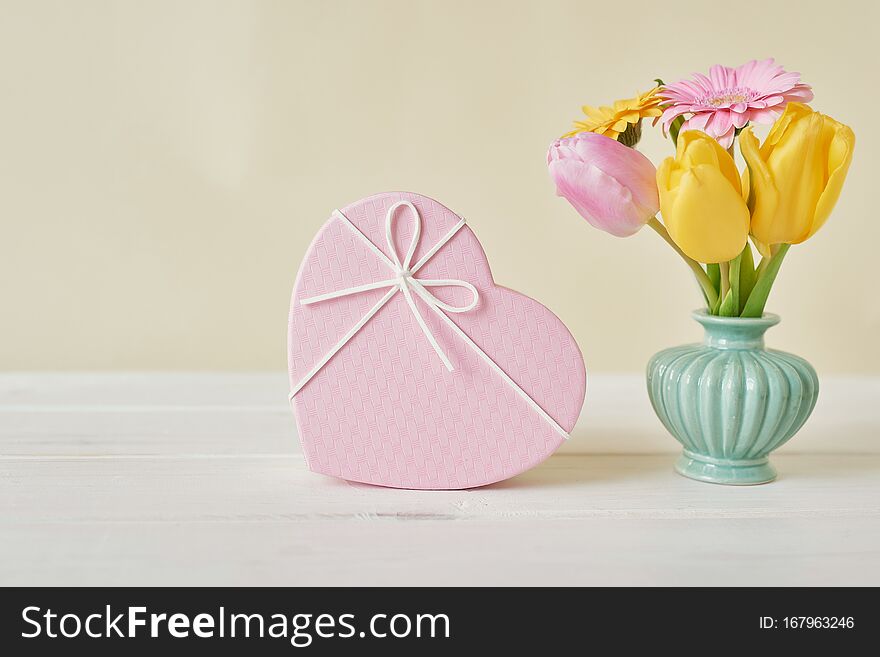 Valentine`s day composition pink gift box with flowers. Valentine card. Greeting card template. Space for text. Concept of Happy Valentine`s day. Mother`s day card. Spring flowers on pink background