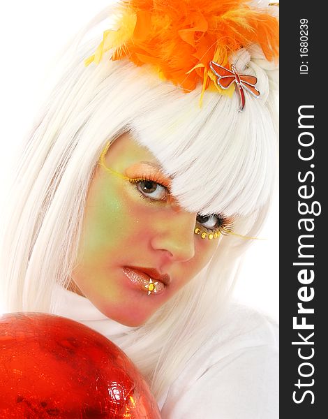 Beautiful young woman in artistic make-up holding orange orb. Beautiful young woman in artistic make-up holding orange orb.