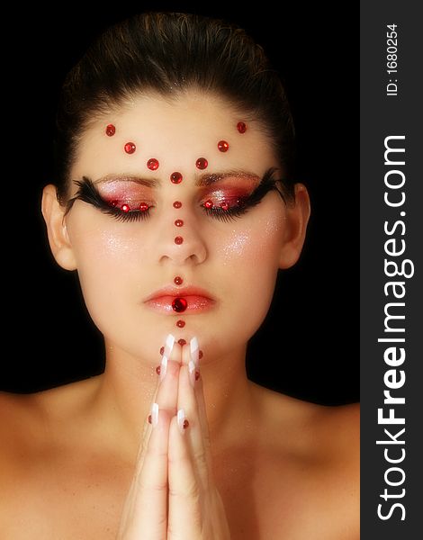 Beautiful young woman in artistic make-up and beads. Praying. Beautiful young woman in artistic make-up and beads. Praying.