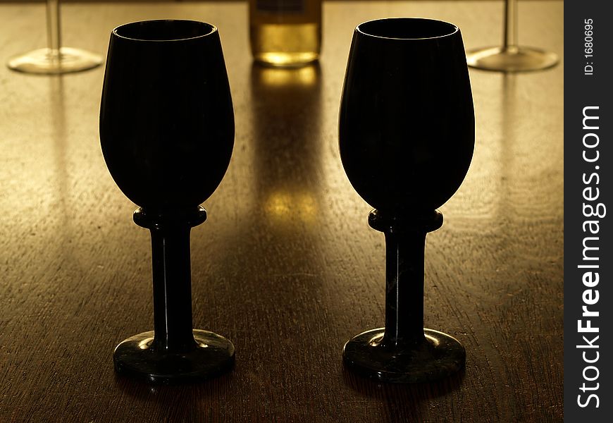 2 black winecups with bottle of white wine in the background