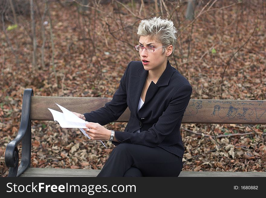 Business woman outdooring a park reading mails and notebook. Business woman outdooring a park reading mails and notebook
