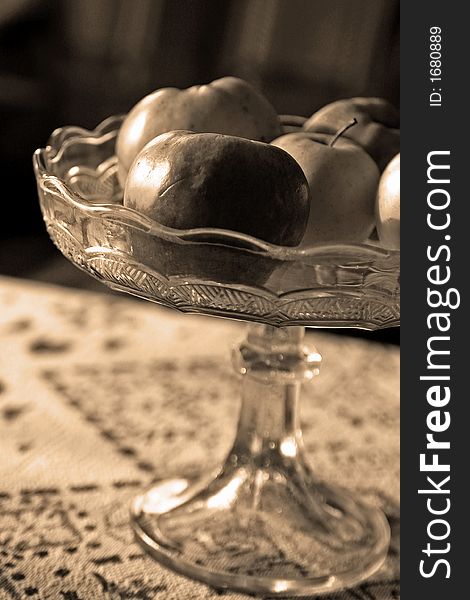 Some apples in sepia colors in a glass bowl