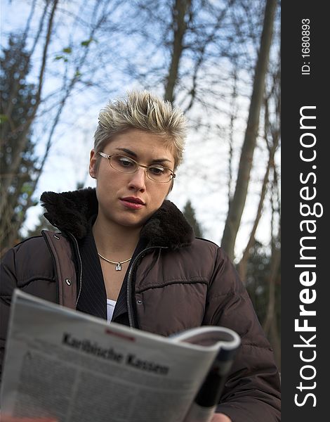 Business woman outdoor in a park reading a magasine