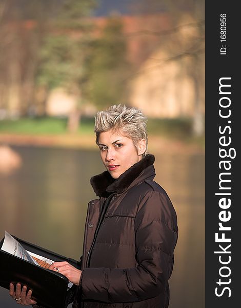 Business woman outdoorin a park reading mails and notebook. Business woman outdoorin a park reading mails and notebook