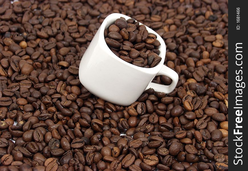 White coffe cup with black and brown beans