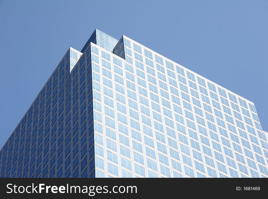 Geometrical skyscraper rises in the cloudless sky