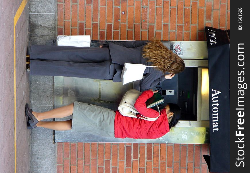 Two girls by the money-automat. Two girls by the money-automat.