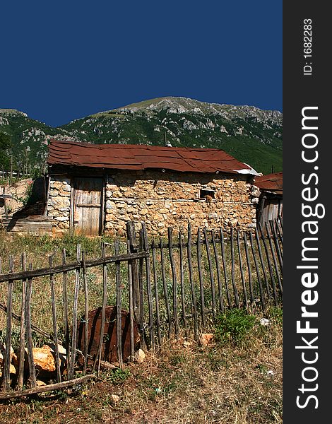 Old abandoned house with wooden fence in foreground