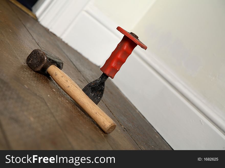 Hammer and chisel on a wooden floor