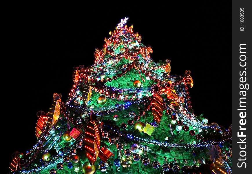 Pine-tree decorated with lights & garlands in holy night. Pine-tree decorated with lights & garlands in holy night