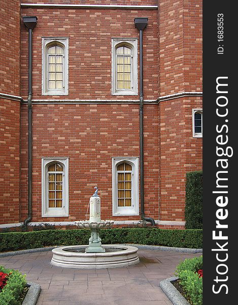 Architectural details of british style courtyard with fountain and brick wall in background