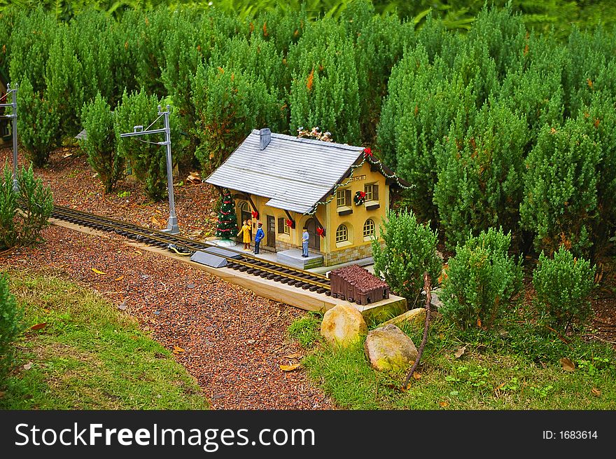 Model of train station between miniature forest with christmas decoration