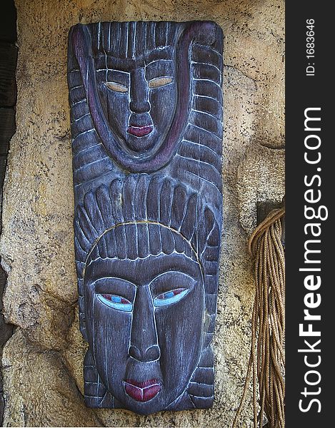 Traditional african mask hanging on grunge stone wall