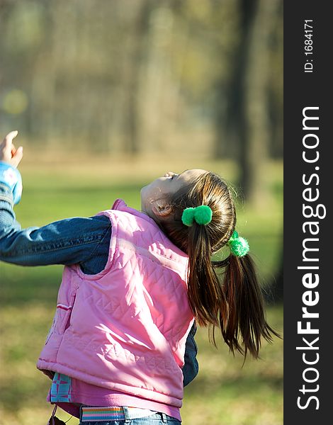 A little pretty child looking up in the park