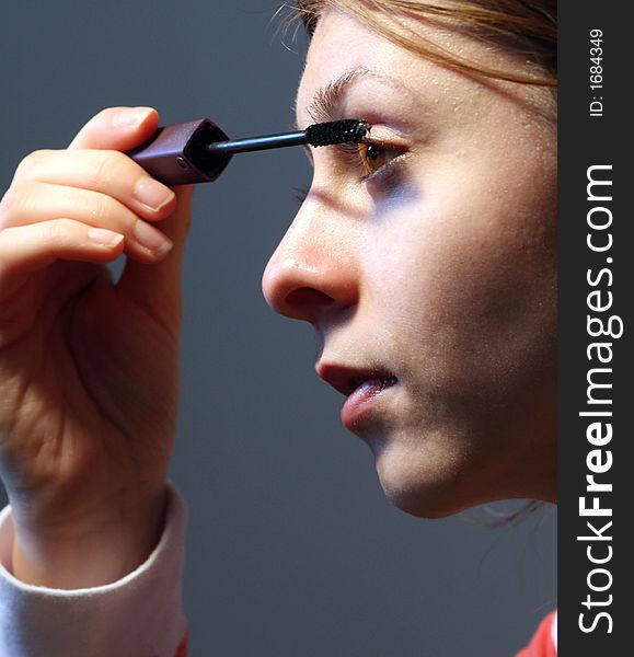 Woman applying mascara on her eyelashes. Woman applying mascara on her eyelashes