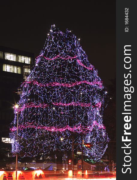 Festive decorated tree during a street illumination festival in Sendai.In the bottom of the image there is a motion blur generated by the traffic.
