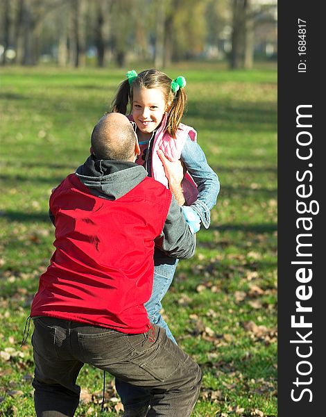 Little pretty child happy running to father in the park