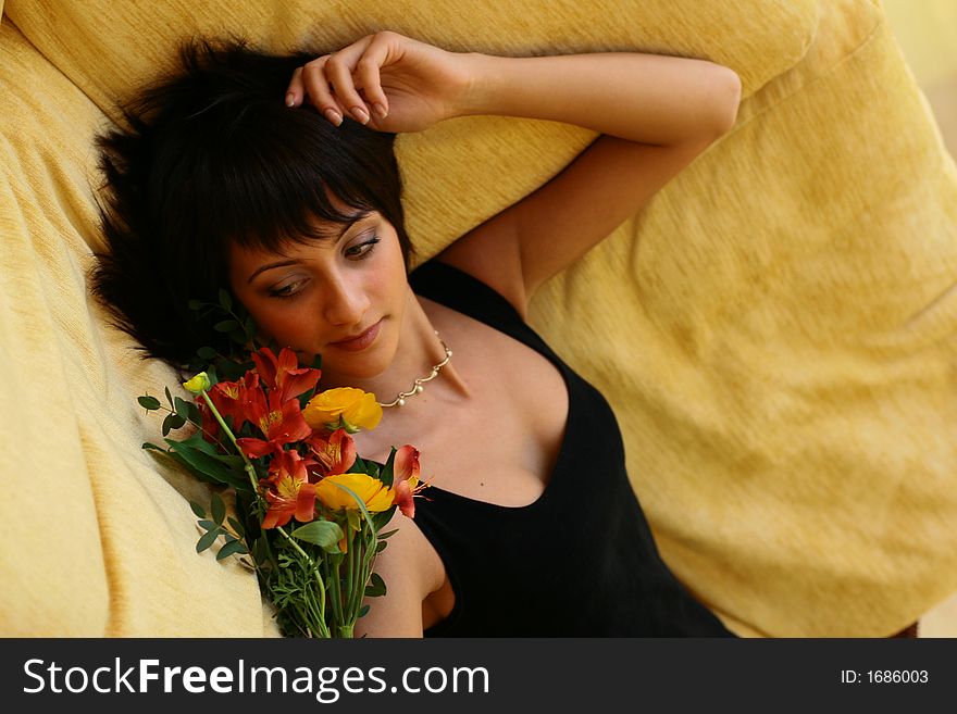 Young girl with flowers laying on a sofa
