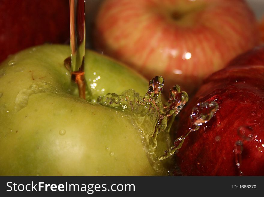Large, ripe apples under a jet of water. Large, ripe apples under a jet of water.