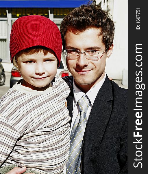 Corporate man with a small  boy in a red hat